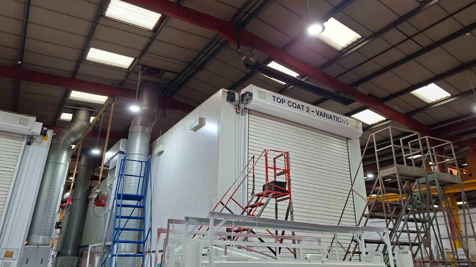 Industrial spray booth with extraction ducting in a paint spraying workshop
